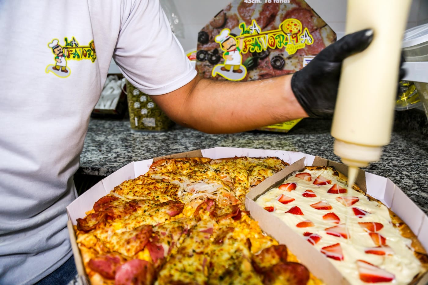 Pizzaiolo cortando pizzas na bancada da La Favorita